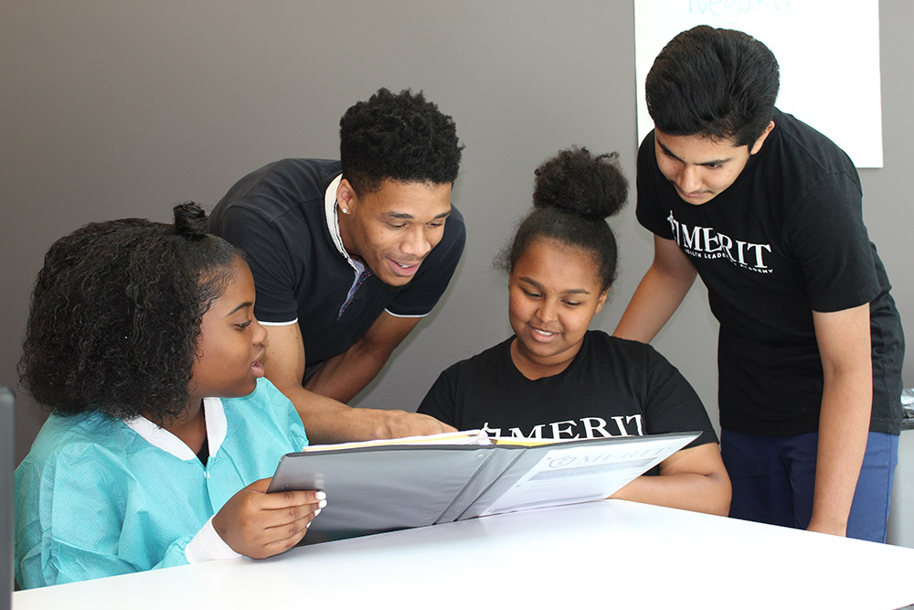 young adults looking at a binder